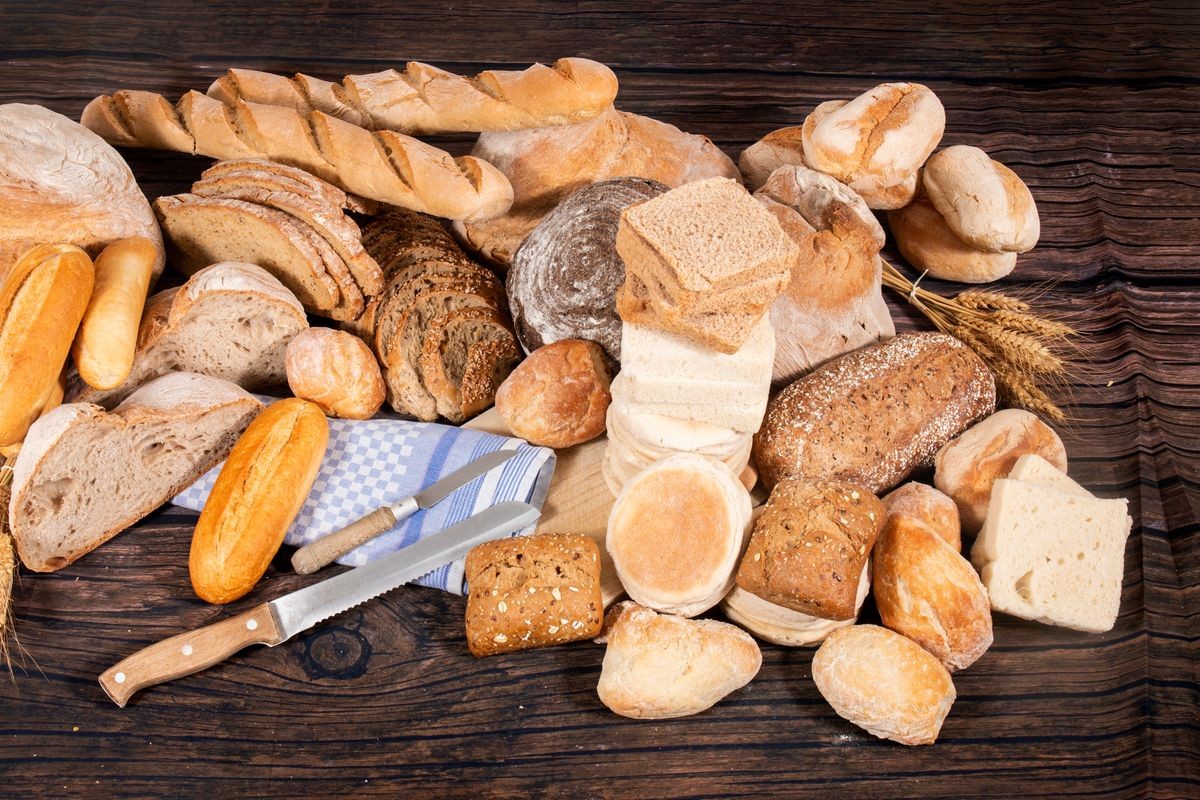 Fresh Assortment of several baked bread varieties on a wooden table.